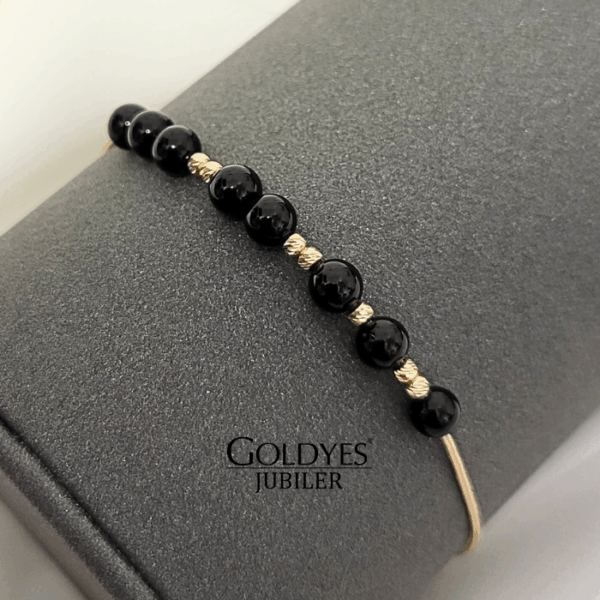 złota bransoletka na złotym sznurku z czarnym turmalinem i diamentowanymi kulkami próba złota 585